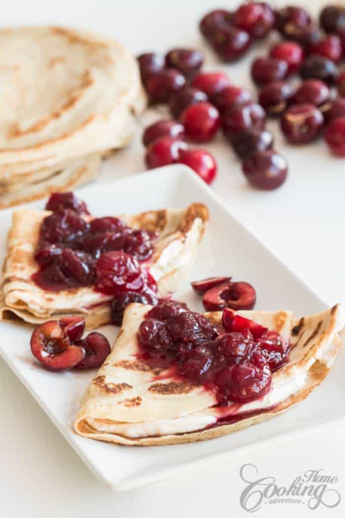 cherry and cream cheese crepes on white rectangular plate