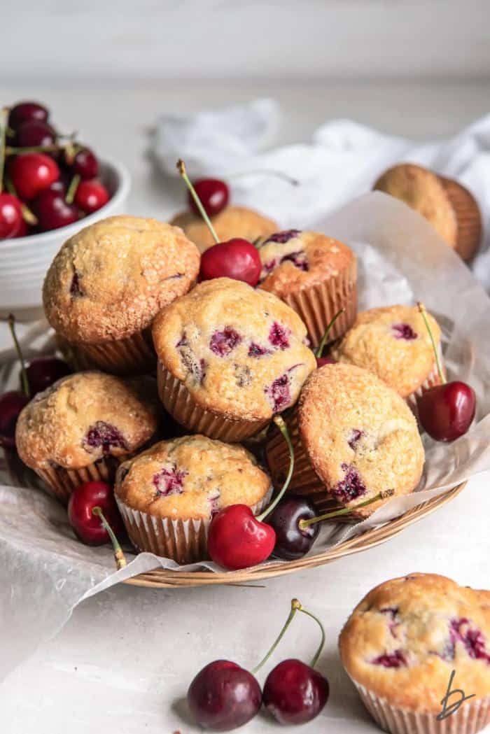 cherry muffins stacked in a basket