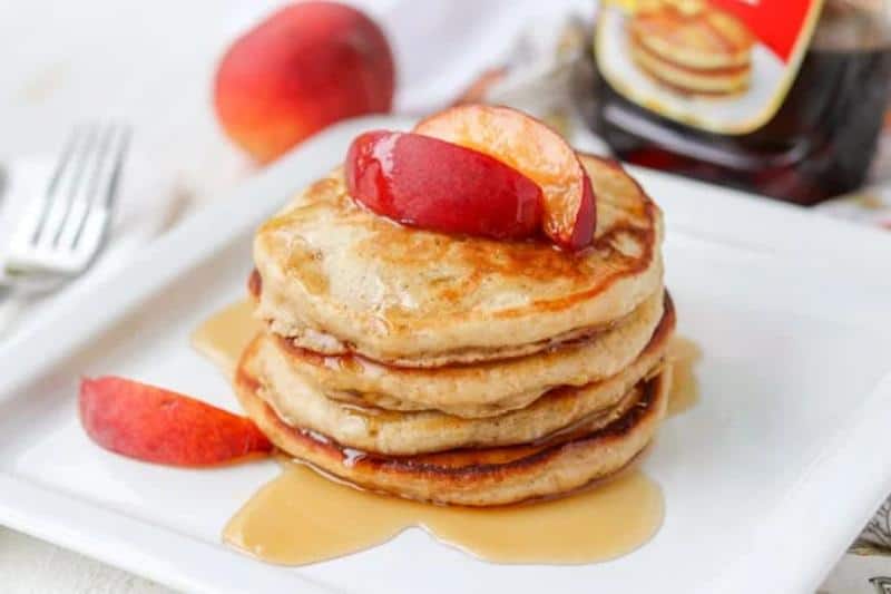 stack of cinnamon peach pancakes on white square plate
