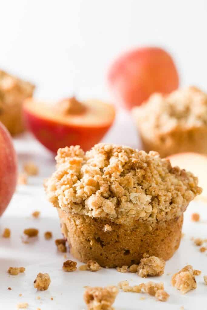 peach cobbler muffins surrounded by crumble and peach halves