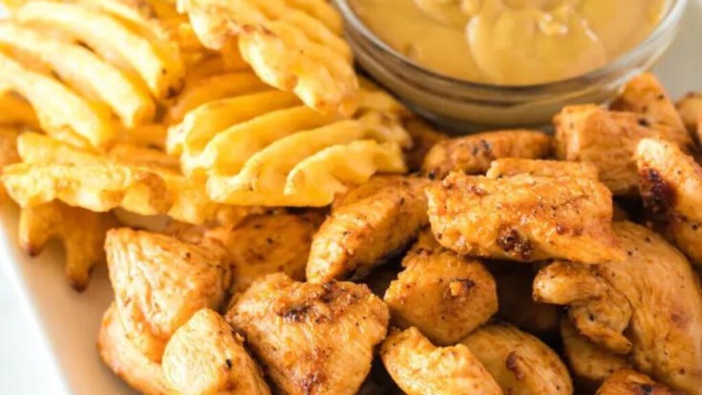 a plate of grilled chicken nuggets with waffle fries