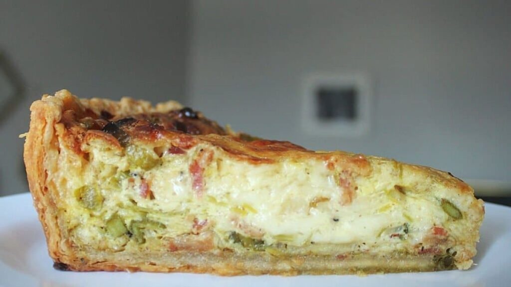 a slice of quiche with leeks, asparagus and bacon