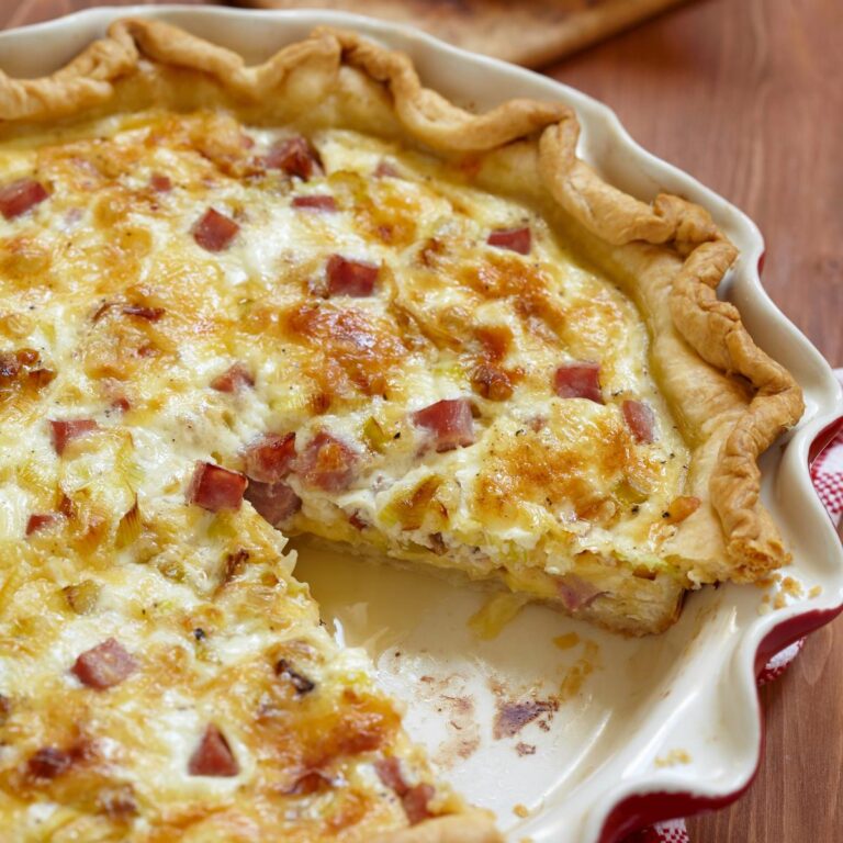 quiche lorraine in a pan with one wedge removed
