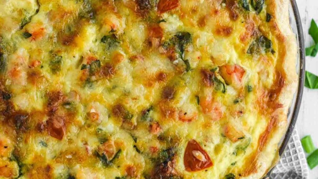 a quiche filled with shrimp, tomato and cheese