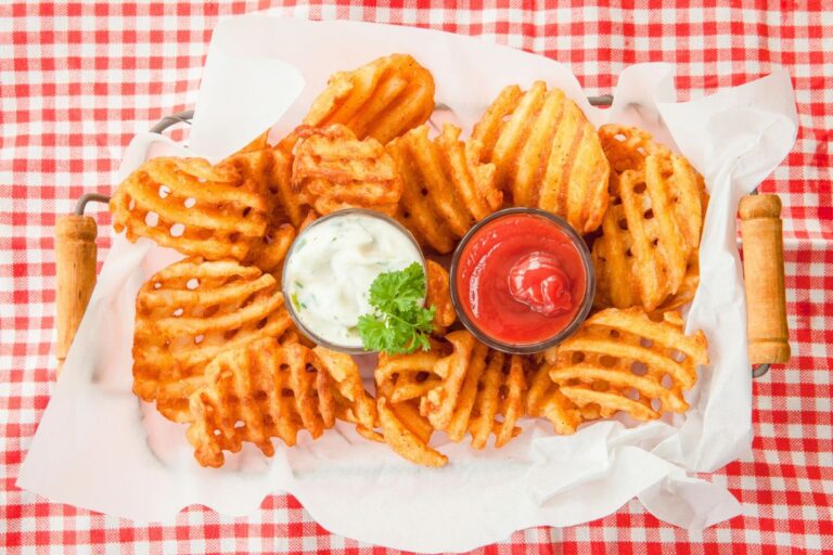 a basket of waffle fries with ketchup and ranch