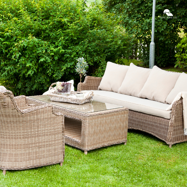 A cozy outdoor seating area featuring a wicker sofa, chairs, and a glass-top coffee table set on a lush green lawn, perfect for family gatherings.