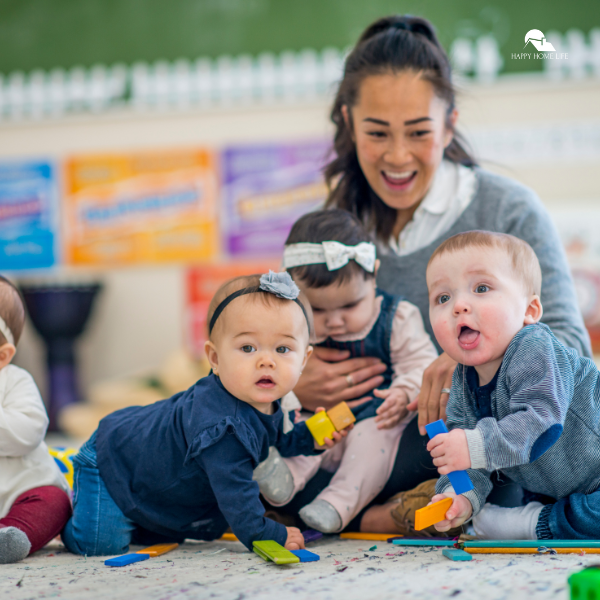 A daycare provider smiling while engaging with a group of babies playing with toys, highlighting how daycare supports work-life balance for families.